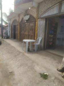 a white table and two chairs in front of a building at EBORA cultura afro in Ilhéus
