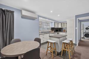 a kitchen with a table and stools in a room at The Brynes Hideaway - On Brynes Road in Goolwa +18 photos