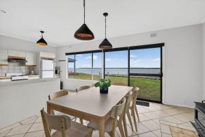 a kitchen and dining room with a table and chairs at Barnacles Shack - Mills Road in Hindmarsh Island