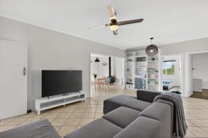 a living room with a couch and a flat screen tv at Barnacles Shack - Mills Road in Hindmarsh Island +36 photos