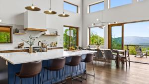 a kitchen with a large white counter and chairs at Bates Ridge by AvantStay in Tannersville