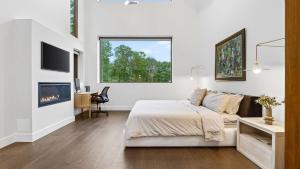 a white bedroom with a bed and a fireplace at Bates Ridge by AvantStay in Tannersville