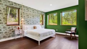 a bedroom with green walls and a bed and a chair at Bates Ridge by AvantStay in Tannersville