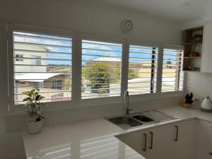 a kitchen with a sink and two windows with a view at 2 Shore Ct - Shore Thing in Goolwa South