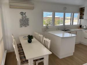 a kitchen with a table and a white counter top at 2 Shore Ct - Shore Thing in Goolwa South