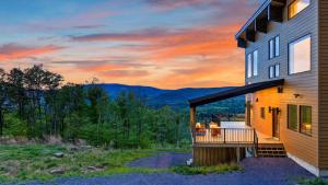 a house with a deck with a view of the mountains at Bates Ridge by AvantStay in Tannersville