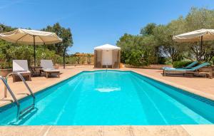a swimming pool with two chairs and an umbrella at Estrella - Son Jorbo in Porreres
