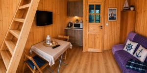 a room with a table and a chair and a kitchen at Domki Boja in Swarzewo