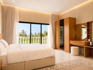 a bedroom with a large bed and a large window at Al Reef Garden in Sohar +28 photos