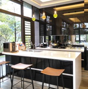 una cocina con un gran mostrador blanco con taburetes en Sunny Stream B & B, en Wujie