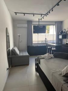 a bedroom with a bed and a chair and a television at Studio lnhô Tim in Brumadinho