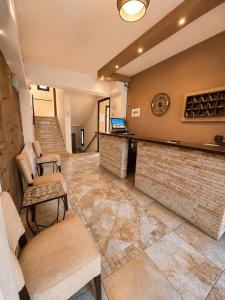 a lobby with a bar and chairs and a staircase at Kladis Club Holidays in Skala Potamias