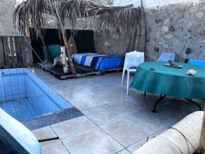 a room with a bed and a table and a tub at Huanchaco Surf Camp in Huanchaco