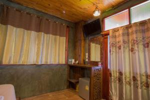 ein Badezimmer mit Vorhängen, einem Spiegel und einem TV in der Unterkunft Sea Rock Resort in Haad Pleayleam