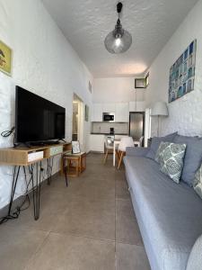 a living room with a couch and a flat screen tv at parking terraza jumbo by stay in gran canaria in Playa del Ingles