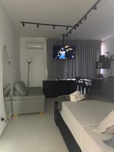 a bedroom with two beds and a tv on the wall at Studio lnhô Tim in Brumadinho