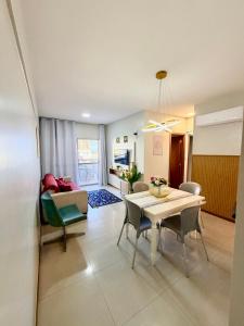 a living room with a table and a couch at Apt 3 quartos com área de lazer in Belém