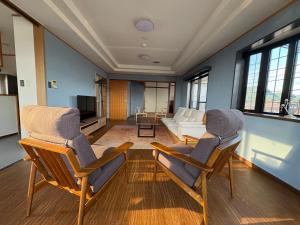 a living room with two chairs and a couch at はなれ香 in Kirishima