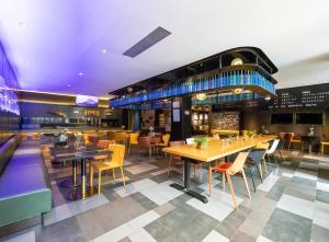 a restaurant with wooden tables and yellow chairs at CitiGO Hotel Shanghai Xujiahui in Shanghai