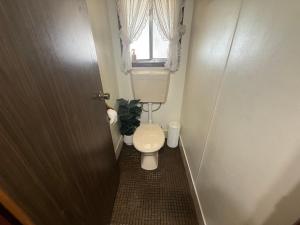 a small bathroom with a toilet and a window at Flahertys Retreat in Point Turton +6 photos