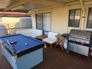 a patio with a pool table and a grill at Flahertys Retreat in Point Turton