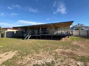 a building with a porch and a grass yard at Flahertys Retreat in Point Turton