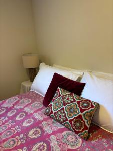a bed with two pillows on top of it at Lulu's Cottage by Native Forest in Waimauku