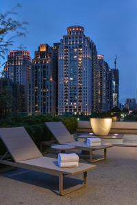 a group of lounge chairs in front of a city skyline at Millennium Hotel Taichung in Taichung
