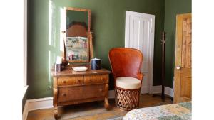 a bedroom with a mirror and a chair and a dresser at Remington in Cimarron
