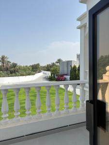 a balcony with white railings and a green lawn at Al Reef Garden in Sohar