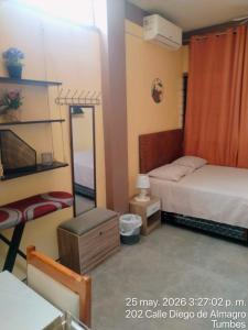 a small bedroom with a bed and a mirror at Departamento Moderno y Acogedor con aire acondicionado in Tumbes