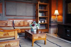 a living room with wooden furniture and flowers on a table at Tegeg's Homestay in Keramas