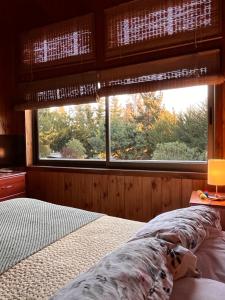a bedroom with a bed in front of a window at Cabañas Bosques de Puertecillo in Puertecillo +47 photos