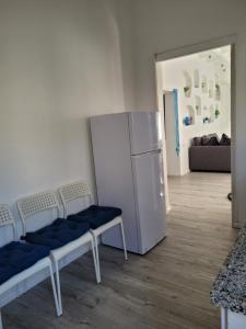 a living room with chairs and a refrigerator at Serenity Apartment in Dalia in Dāliyat el Karmil