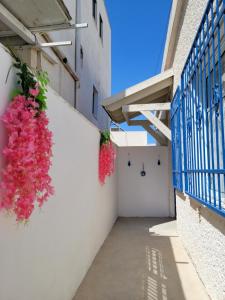 a corridor with flowers hanging on a wall at Serenity Apartment in Dalia in Dāliyat el Karmil