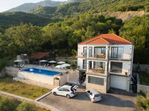 a house with a swimming pool and two cars parked at Stanisicguesthouse in Stanišiči