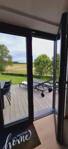 a room with a view of a deck with a table at La Terrasse d'Arthur et Manon in La-Roche-en-Ardenne