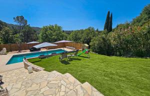 a backyard with a swimming pool and a green lawn at Nice Home In Peymeinade in Peymeinade