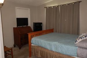 a bedroom with a bed and a desk with a television at Dodge Residence in Tucson