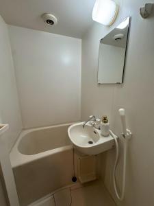 a white bathroom with a sink and a bath tub at Palette Kuhonji in Kumamoto +20 photos