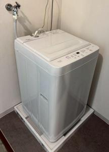 a washing machine sitting on a shelf in a room at Palette Kuhonji in Kumamoto