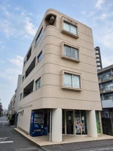 a tall building with windows on a city street at Palette Kuhonji in Kumamoto