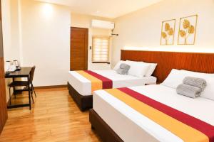 a hotel room with two beds and a desk at Starhomes Hotel & Cafe in Tarlac +13 photos