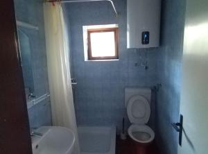 a bathroom with a toilet and a sink and a window at Casa del Mar Rooms in Lopud