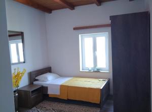 a bedroom with a bed and two windows at Casa del Mar Rooms in Lopud +14 photos