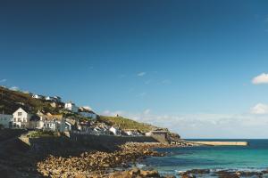 a group of houses on a hill next to the ocean at The Old Success Inn in Sennen Cove
