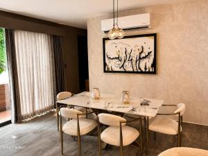 a dining room with a white table and chairs at Casa Palermo con Jacuzzi in Los Mochis +17 photos