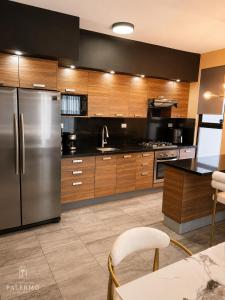 a kitchen with a stainless steel refrigerator and wooden cabinets at Casa Palermo con Jacuzzi in Los Mochis