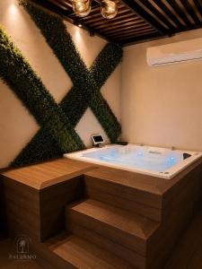a jacuzzi tub with a green wall at Casa Palermo con Jacuzzi in Los Mochis
