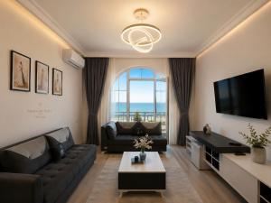 a living room with a couch and a tv at SAkura Hotel Astara in Astara